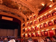 Interior of an ornate opera house with gilded balconies